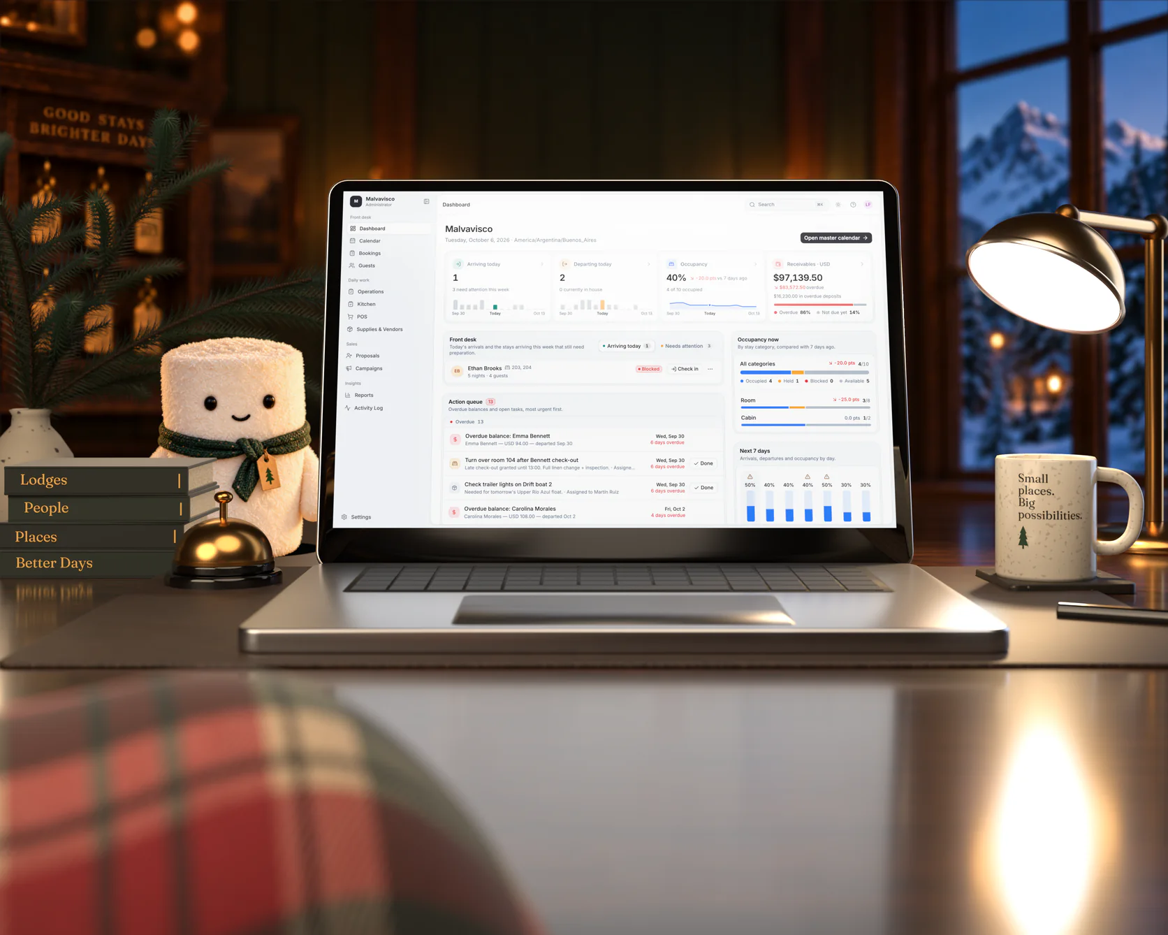 The Malvavisco marshmallow on a lodge front desk at night, beside a laptop showing the LodgeOps dashboard.